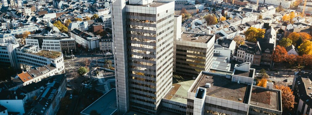 Luftbild des Bonner Stadthauses mit der Innenstadt und dem Siebengebirge im Hintergrund.